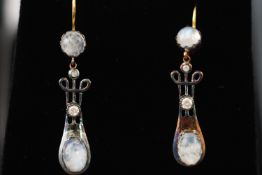 A pair of drop earrings set with cabochon moonstone and diamonds. Hook fitting.