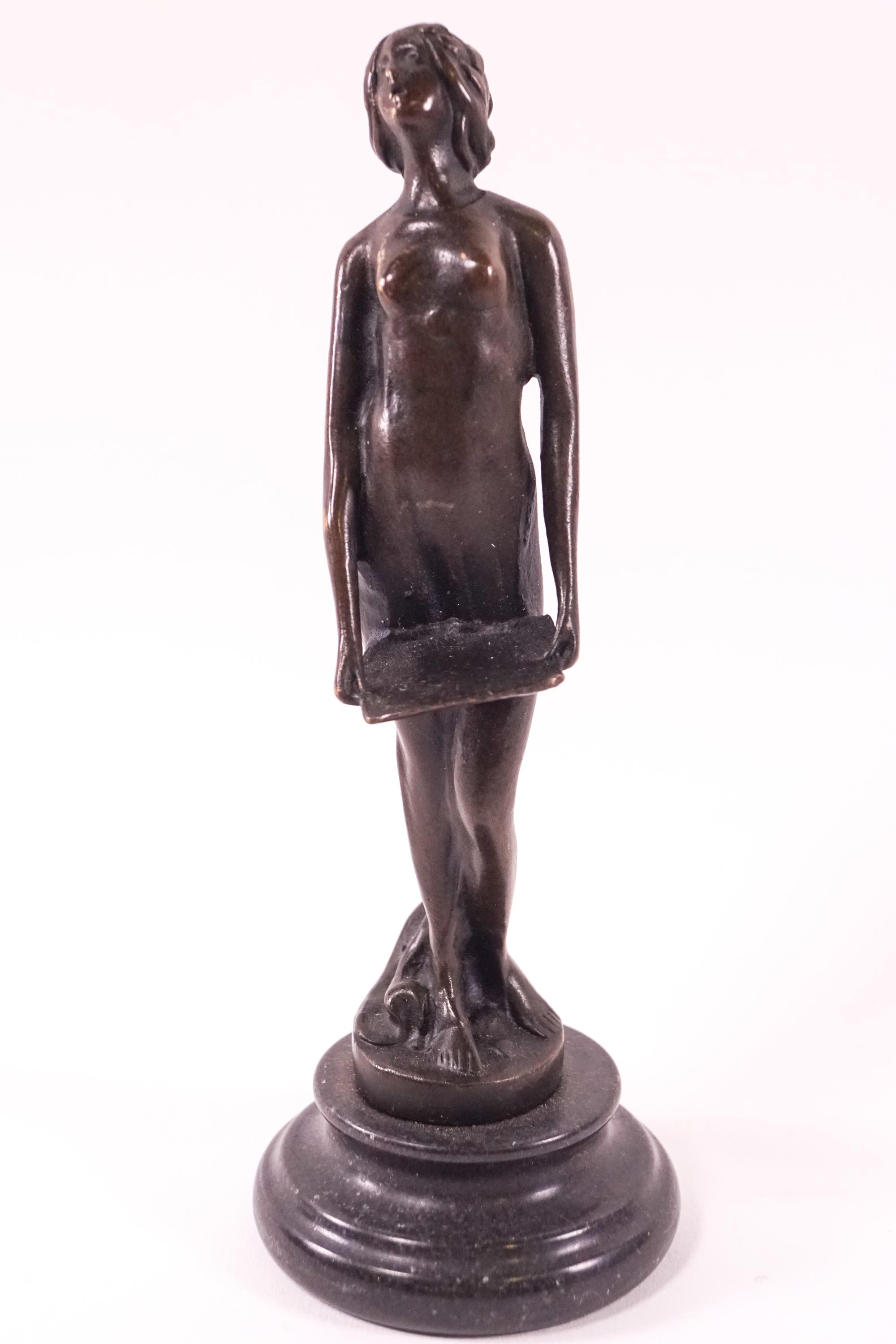 A bronze figure of a Diaphanously clothed singing lady, raised on a turned stone base,
