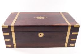 A Victorian brass bound writing slope with secret drawer, the rosewood body with central escutcheon,