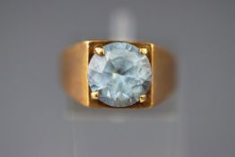 A yellow metal single stone ring set with a round faceted cut synthetic blue spinel. Size N.