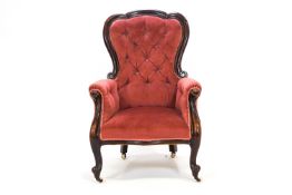 A Victorian carved mahogany lady's armchair with scrolled back with deep buttoned upholstery,