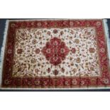 A machine woven Keshan style rug with central medallion issuing scrolling flowers on a beige ground