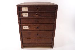 A watch makers multi purpose drawer cabinet with contents, a selection of watch glass faces,