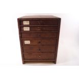 A watch makers multi purpose drawer cabinet with contents, a selection of watch glass faces,