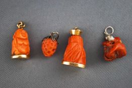 A selection of four carved coral charms having base metal fittings. Gross weight, 20.