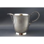 A cream jug of inverted bell form with curved handle and flared foot, London 1953, 7cm high,