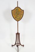 A mahogany pole screen in the 18th century style with shield shaped weighted embroidery