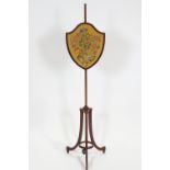 A mahogany pole screen in the 18th century style with shield shaped weighted embroidery