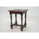 An oak stool, the top pierced with a heart on turned legs linked by stretchers,