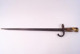 A French bayonet, the steel blade of T section, set to a wood and brass capped handle,
