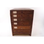 A watch makers multi purpose drawer cabinet with contents, a selection of watch glass faces,