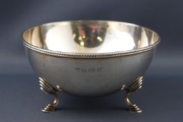 A Hemi spherical silver sugar bowl with applied bead edge raised on three decorated cabriole legs,