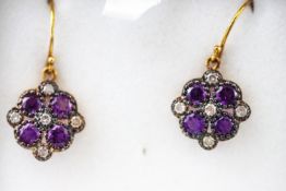 A yellow and white metal pair of floral cluster drop earrings each set with amethysts....