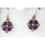 A yellow and white metal pair of floral cluster drop earrings each set with amethysts....