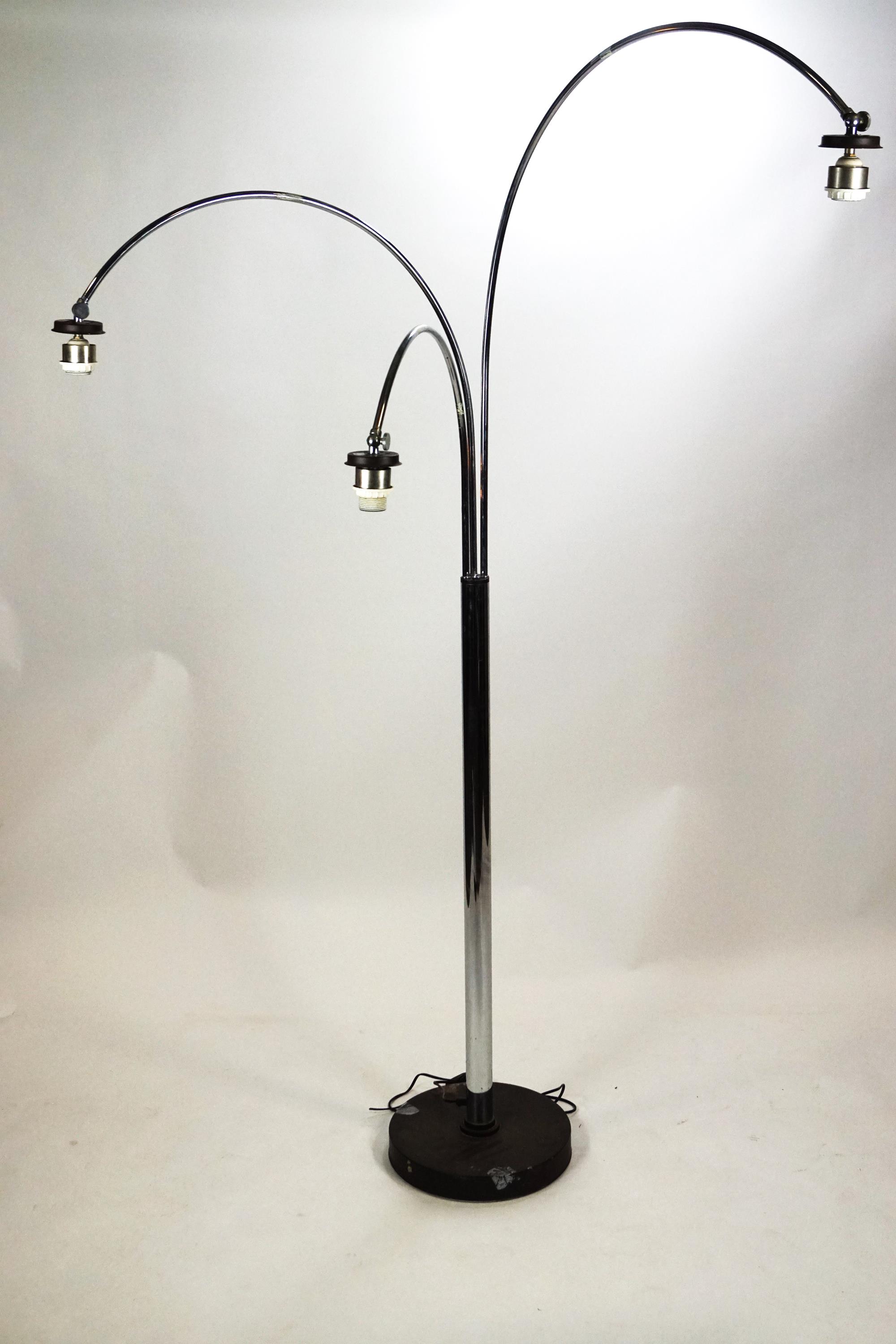 A chrome finished floor lamp with three moveable arch arms