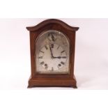 A W & H mahogany cased eight day mantel clock, the arched dial with fast/slow dial,