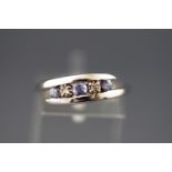 A white metal crossover ring set with tanzanites and diamonds.