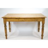 A Victorian pine rectangular kitchen table on turned legs with frieze drawer,