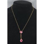 A yellow metal centrepiece drop pendant set with intense pink paste stones.