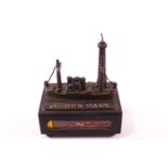 A trench art style match box cover, decorated with a model of the RMS Queen Mary,