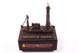 A trench art style match box cover, decorated with a model of the RMS Queen Mary,