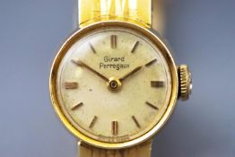 A yellow metal wristwatch. Round champagne baton dial, signed Girard Perregaux.