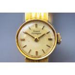 A yellow metal wristwatch. Round champagne baton dial, signed Girard Perregaux.