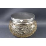 A cut glass dressing jar with silver lid, the bellied body with a variant of hobnail cutting,