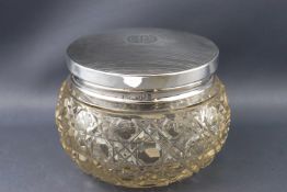 A cut glass dressing jar with silver lid, the bellied body with a variant of hobnail cutting,