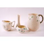 A black mark Belleek basket ware and clover leaf small sugar bowl with two jugs and a vase