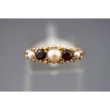 A yellow metal half hoop ring set with garnets and pearls.