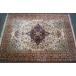 A large Keshan style rug with central medallion on a cream field with scrolling flowers within