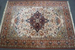 A large Keshan style rug with central medallion on a cream field with scrolling flowers within