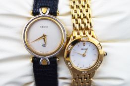 Two wristwatches : A steel and gold plate gucci watch with black leather strap....