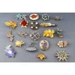 A collection of twenty costume brooches having paste stones or enamel finish.