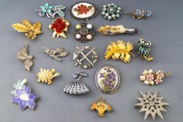 A collection of twenty costume brooches having paste stones or enamel finish.