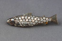 A yellow and white metal brooch stylized as a fish