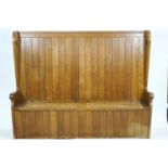 An Oak Arts and Crafts style plain rectangular settle with planked back on side supports