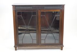 A carved mahogany two door cabinet with plain reed edge rectangular top