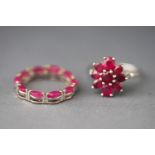 A white metal cluster ring set with round and oval cut composite (glass filled) rubies,