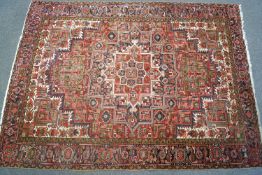 A large carpet with geometric motifs on a cream ground within three borders,