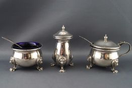 An eighteenth century Irish style three piece cruet set of plain belied form with lion mask