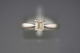 A white metal single stone ring set with an emerald cut diamond of approximately 0.50cts.