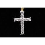 A yellow and white metal cross pendant set with eleven round brilliant cut diamonds.