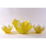 Three glass handkerchief bowls decorated with white stripes on yellow ground,