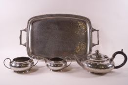 An Art Deco style pewter three piece tea set of low form, with spot hammered and bead decoration,