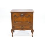 A mid 20th century oak fall front cabinet in the French style with rectangular top over a door