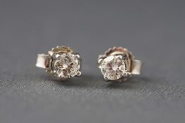 A white metal pair of single stone diamond stud earrings. Estimated total weight 0.20cts.