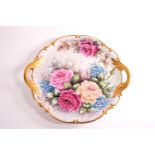 A Hutschenreuther two handled plate in the Rococo style, decorated with roses and forget me nots,