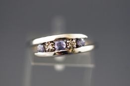 A white metal crossover ring set with tanzanites and diamonds.